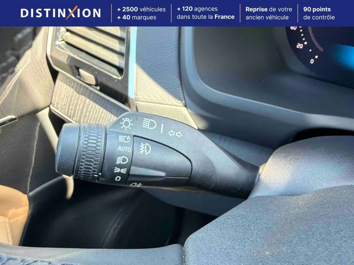 Gros plan sur la commande des feux à gauche du volant dans l’habitacle gris du Volvo XC90 gris 2024.