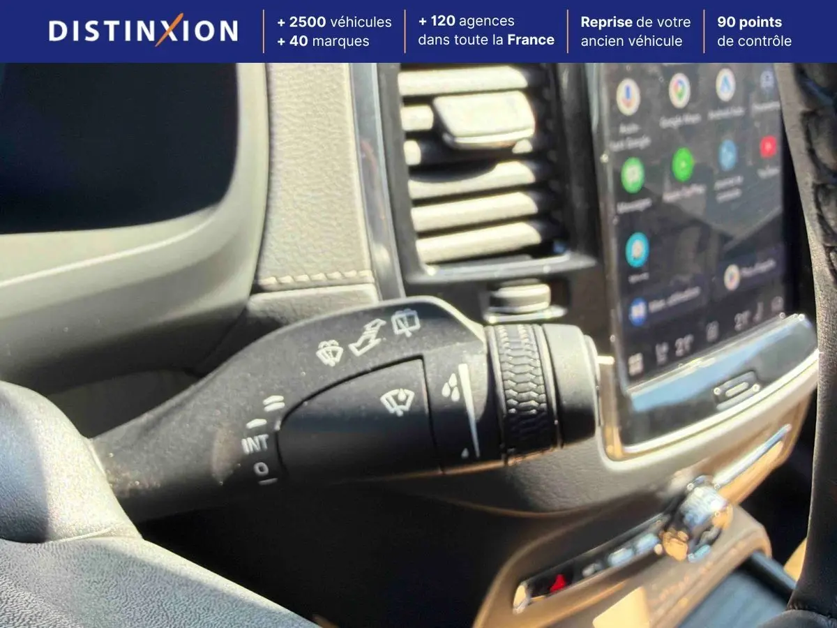 Gros plan sur la commande des essuie-glaces à gauche du volant dans l’habitacle d’un Volvo XC90 gris 2024.