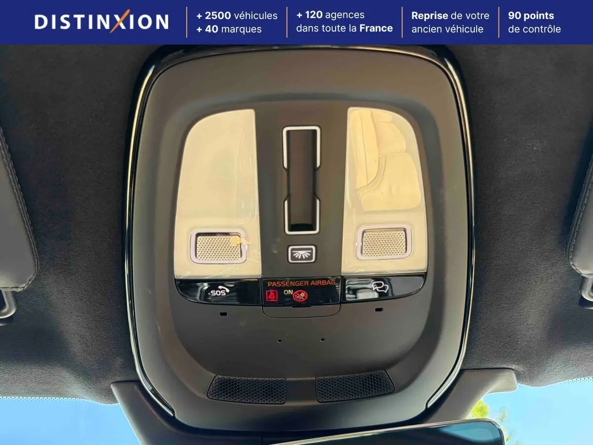 Vue en plongée du plafonnier intérieur gris du Volvo XC90 2024 avec boutons SOS et éclairage intégré.