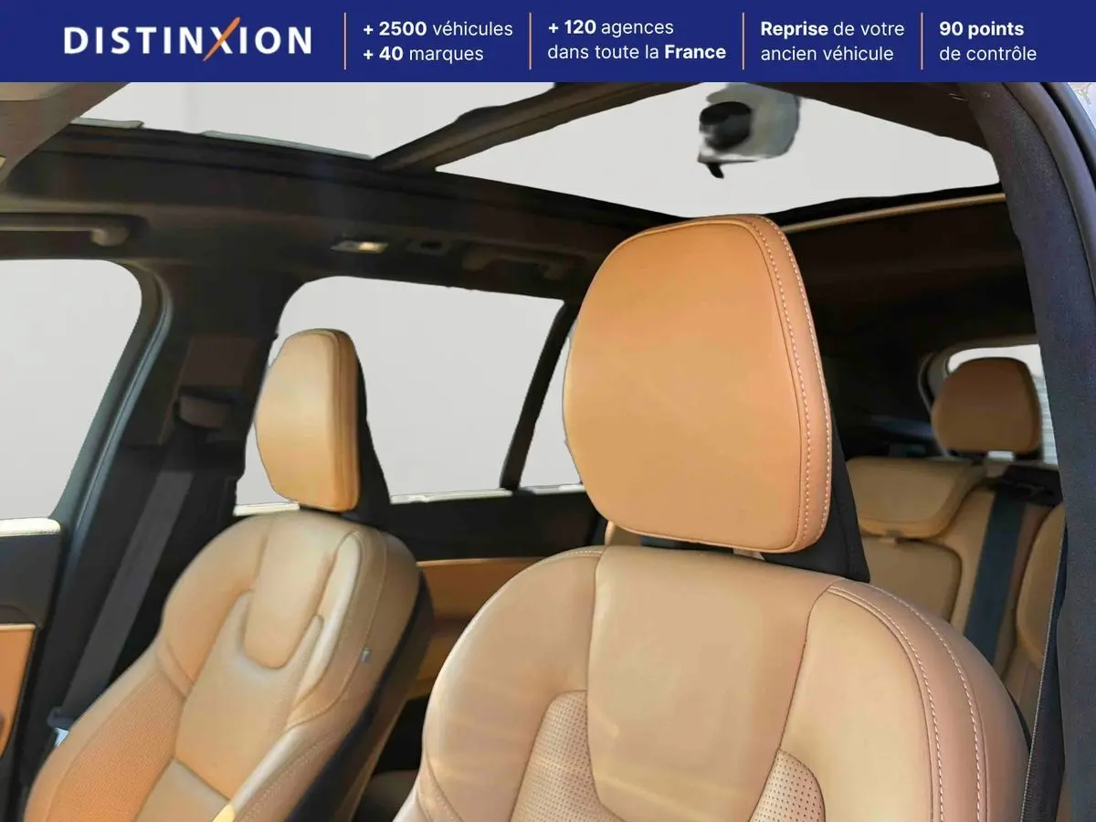 Vue intérieure du Volvo XC90 2024 montrant les sièges avant en cuir beige et le toit ouvrant panoramique.
