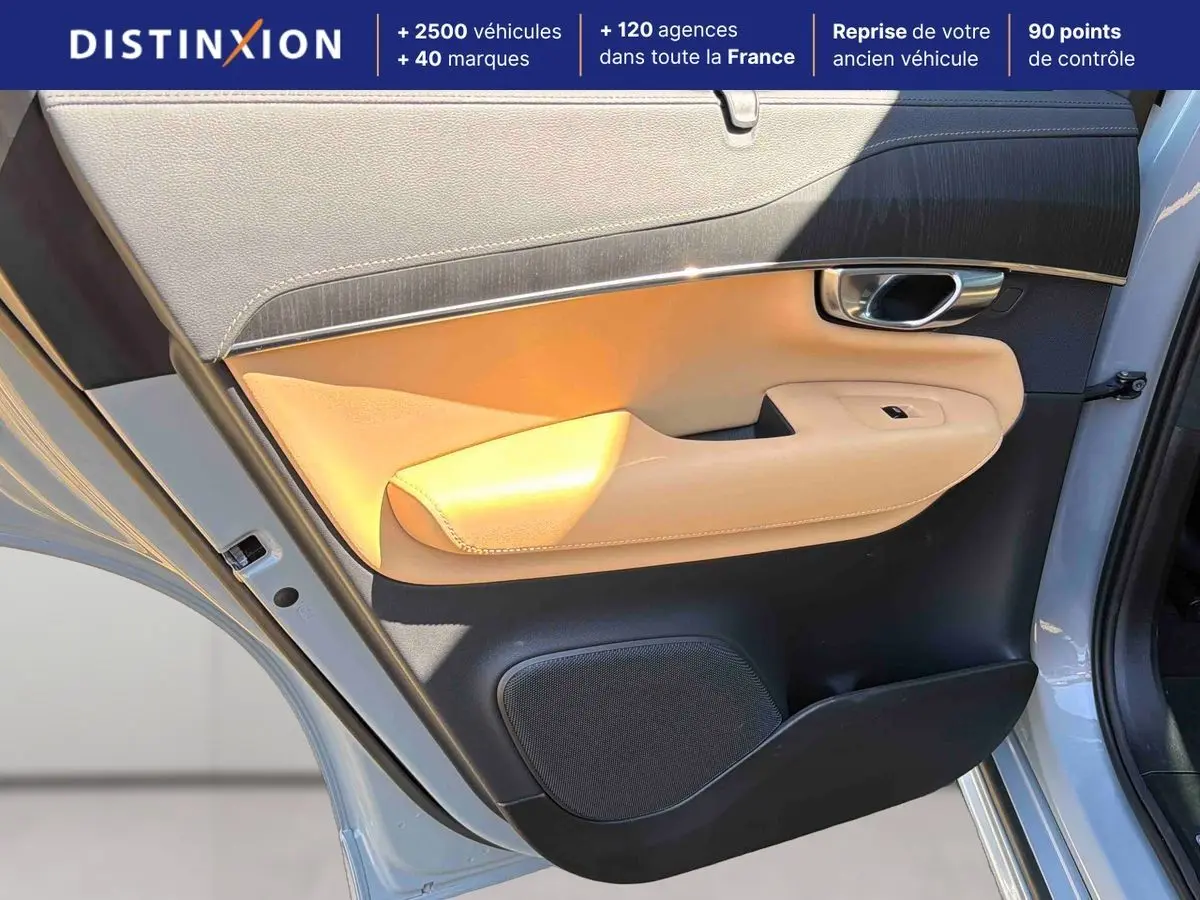 Vue rapprochée de la porte avant gauche grise du Volvo XC90 avec garniture beige et insert chromé autour de la poignée.