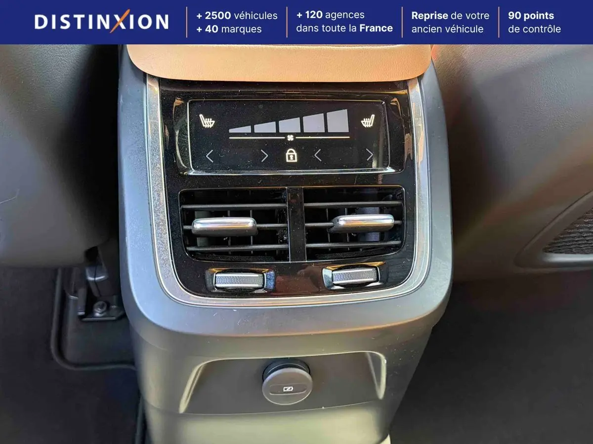 Détail de la console arrière avec commandes de climatisation et prises sur Volvo XC90 gris 2024.
