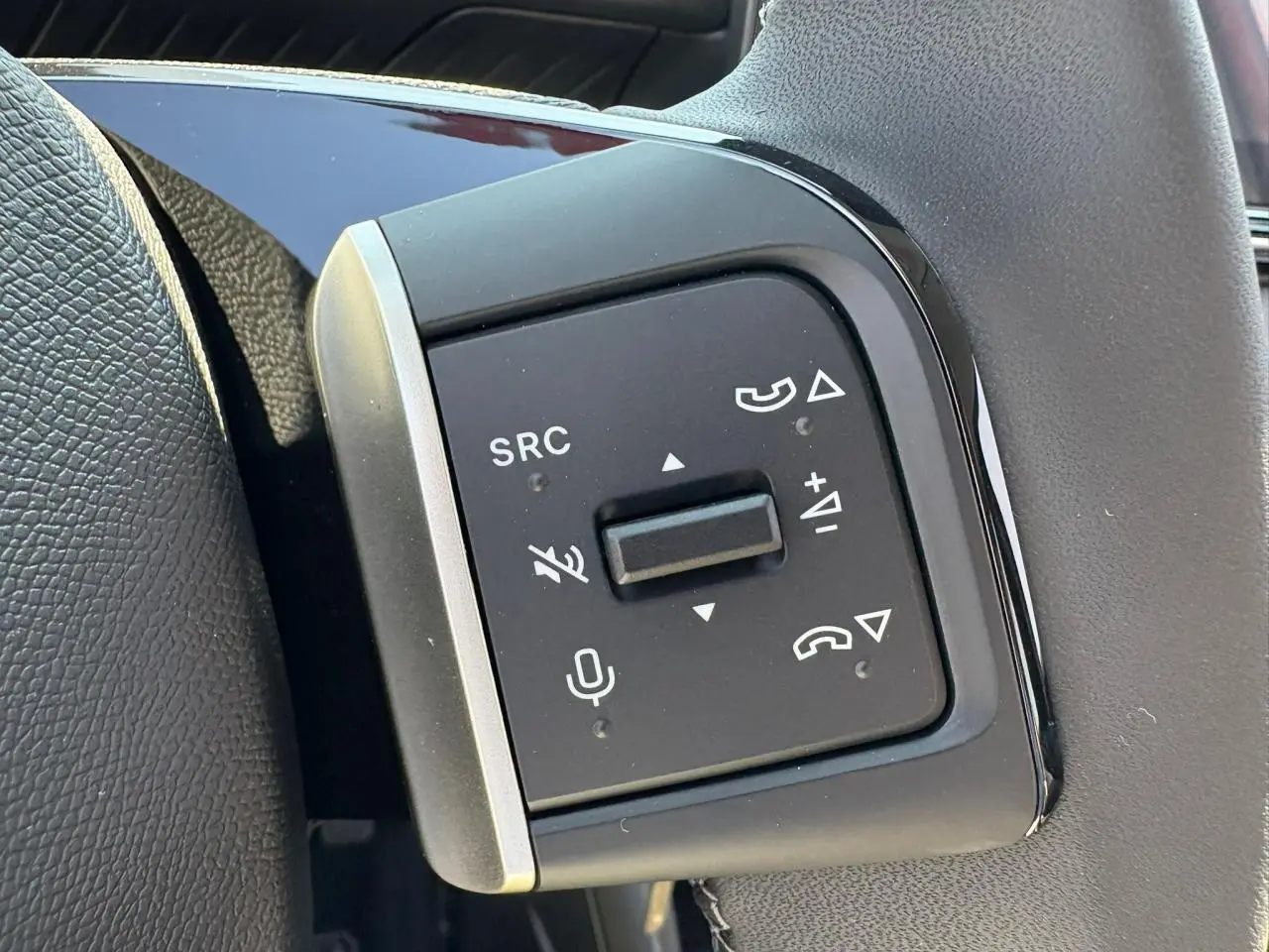 Gros plan sur les commandes au volant gauche du Citroën C3 2025 rouge Elixir avec toit noir.