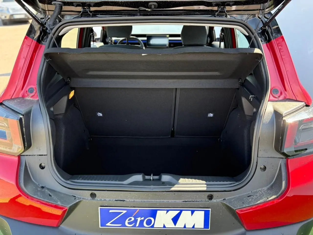 Coffre ouvert vu de l'arrière d'une Citroën C3 2025 Rouge Elixir avec toit noir et feux arrière distinctifs.