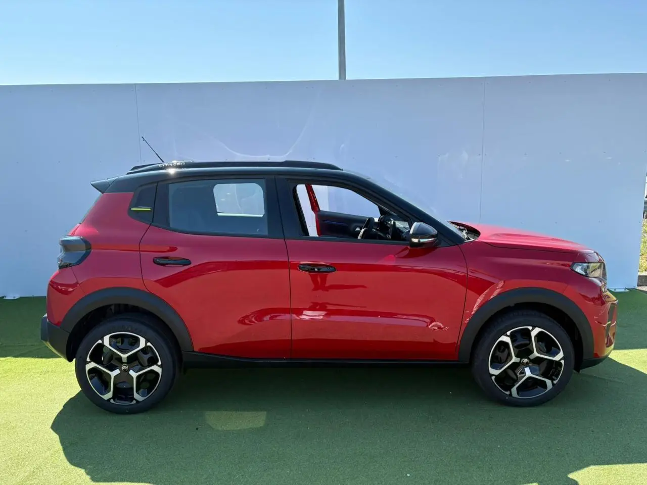 Profil côté gauche d'une Citroën C3 2025 rouge Elixir avec toit noir et jantes 17 pouces AZURITE.