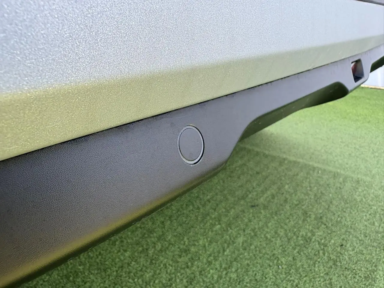 Gros plan sur le bas de caisse noir mat avec capteur de stationnement d'une Citroën C3 Rouge Elixir toit noir.