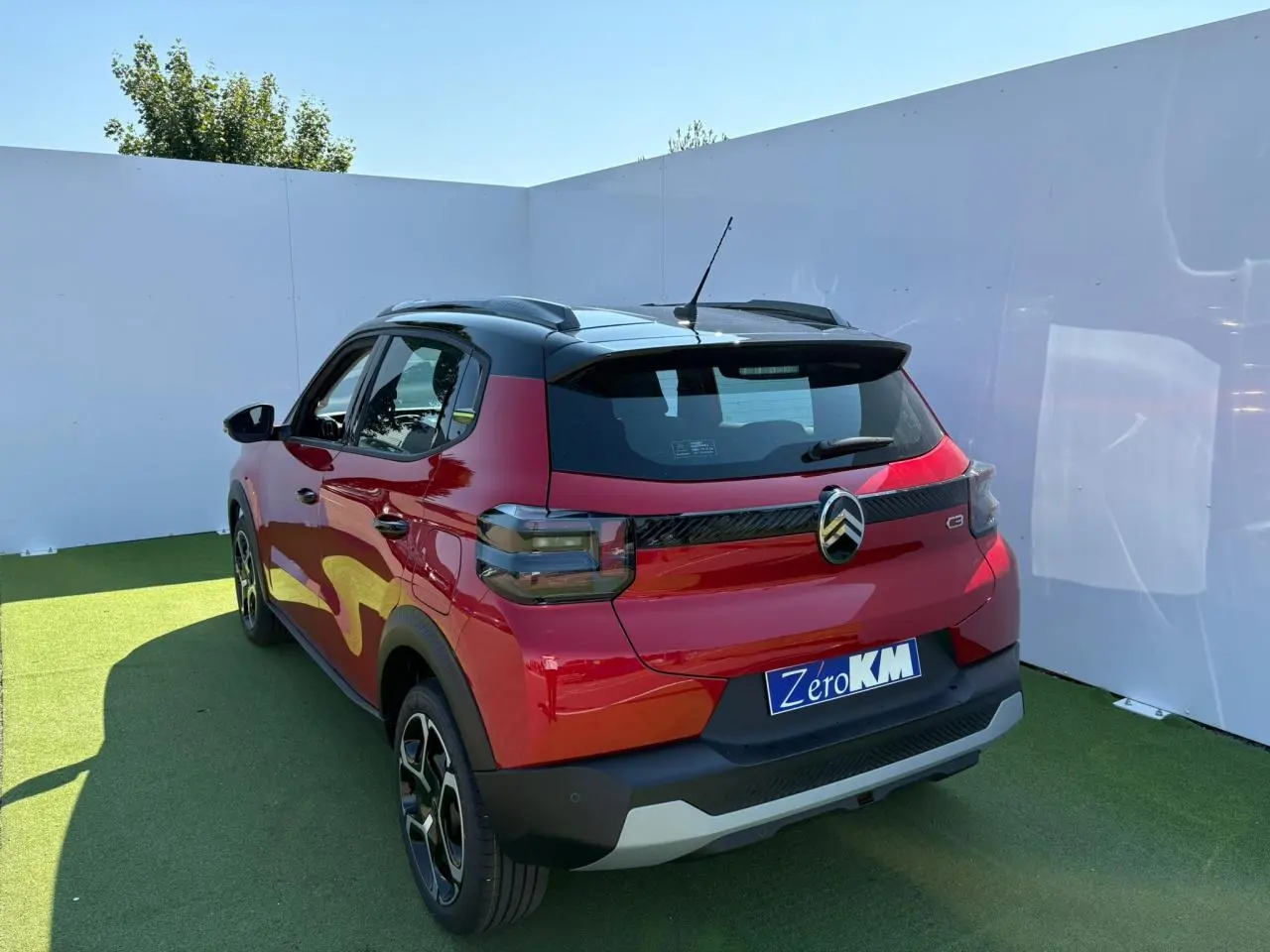 Vue 3/4 arrière droite d'une Citroën C3 2025 rouge Elixir avec toit noir et jantes 17 pouces Azurite.