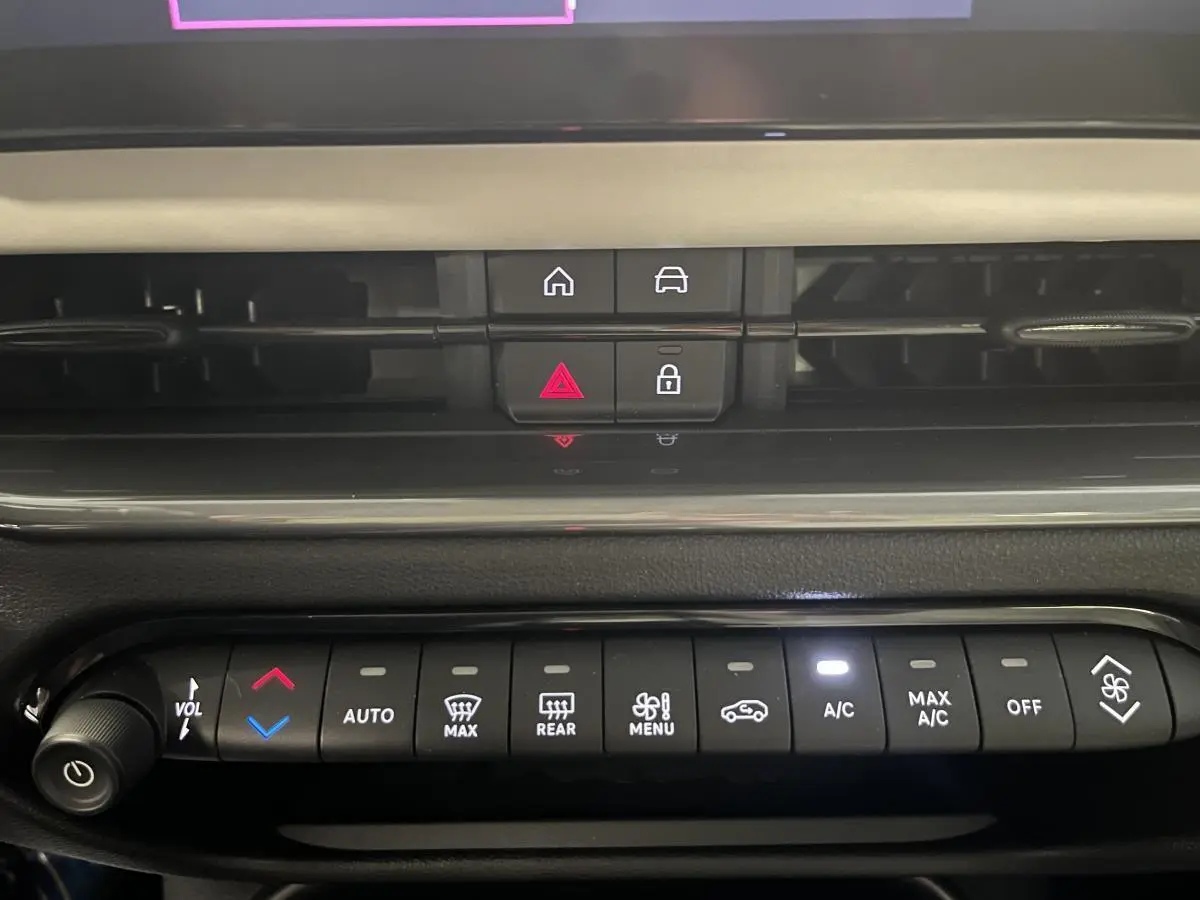 Gros plan sur la console centrale du Fiat 600 La Prima 2024, montrant les commandes de climatisation et ventilation.