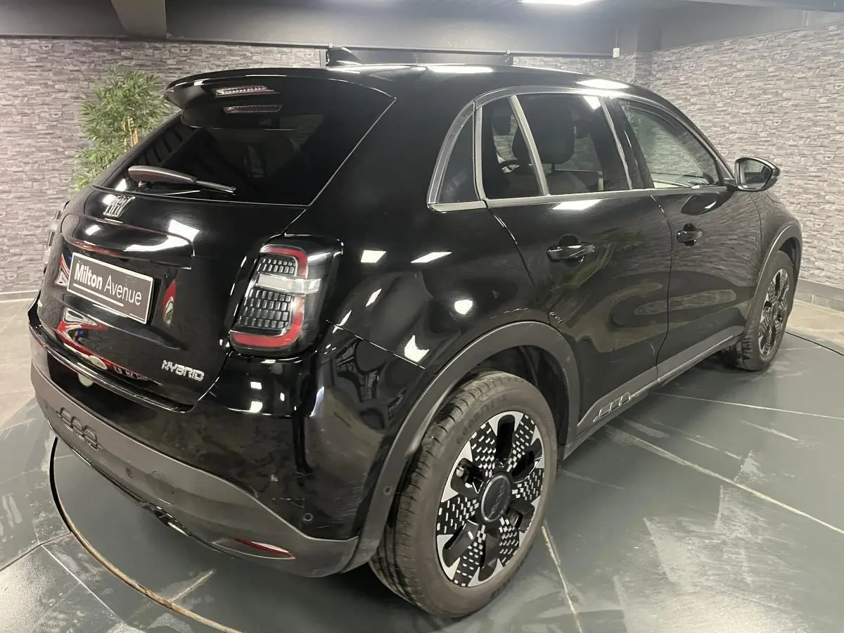 Vue 3/4 arrière droite d'une FIAT 600 hybride noire avec jantes alliage diamantées et feux arrière LED distinctifs.