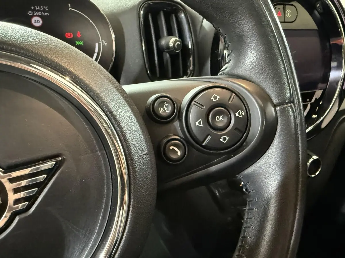 Gros plan sur le volant cuir noir de la MINI Countryman 2020, avec commandes vocales et multimédia visibles côté droit.