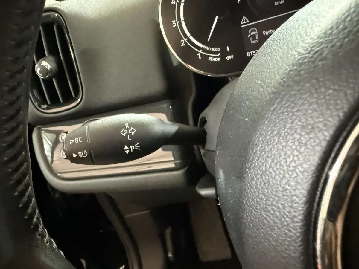 Gros plan sur la manette de clignotants à gauche du volant cuir dans l'habitacle noir du MINI Countryman 2020.
