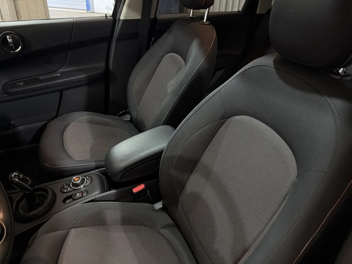 Vue rapprochée des sièges avant noirs et de la console centrale d'une MINI COUNTRYMAN Cooper D Business Design 2020.