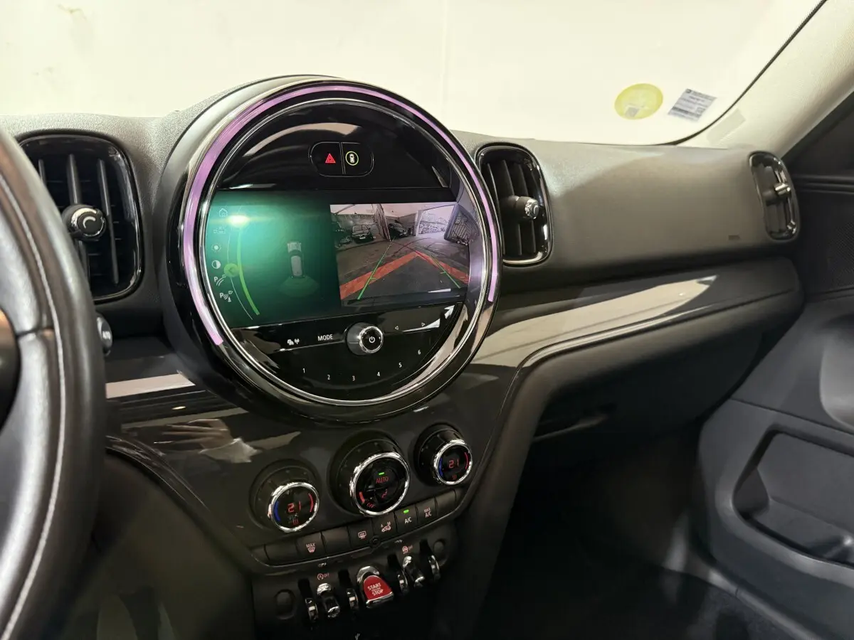 Vue intérieure du tableau de bord noir du MINI COUNTRYMAN 2020 avec écran tactile circulaire affichant la caméra de recul.