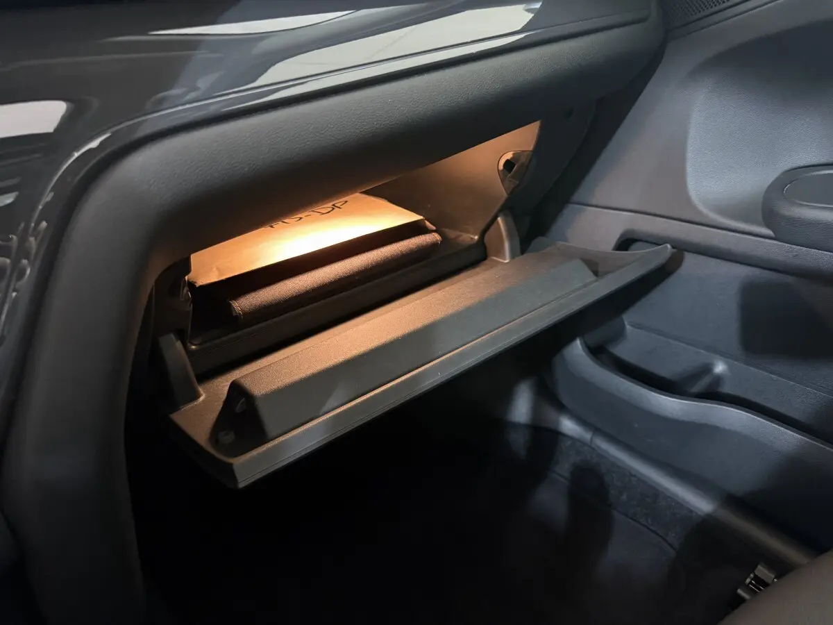 Gros plan sur la boîte à gants ouverte avec éclairage intérieur dans le MINI Countryman Cooper D Business Design 2020.