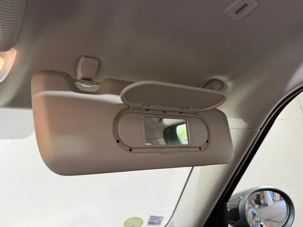 Miroir de courtoisie ouvert côté conducteur dans l'habitacle d'une MINI Countryman noire, vue intérieure rapprochée.