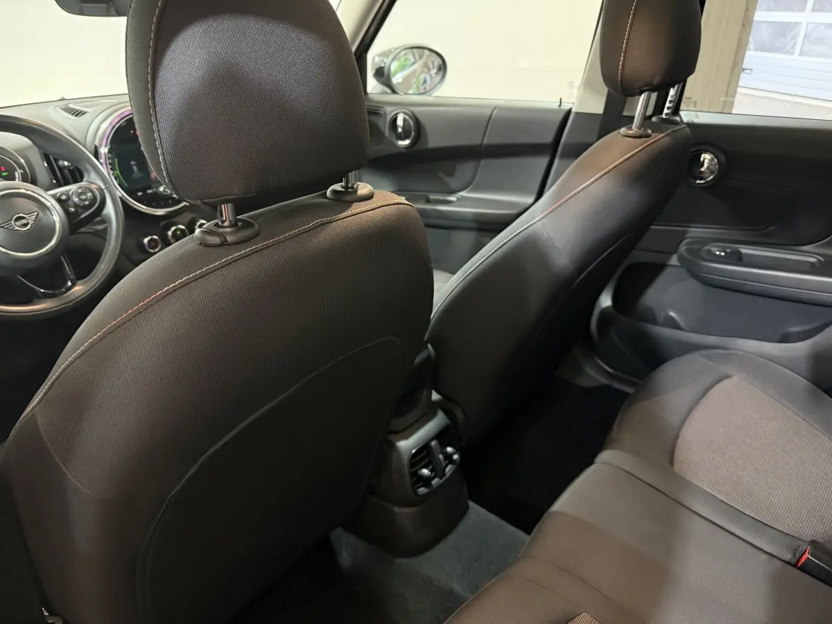 Vue intérieure arrière droite du MINI Countryman noir 2020, montrant les sièges avant et arrière en tissu et cuir.