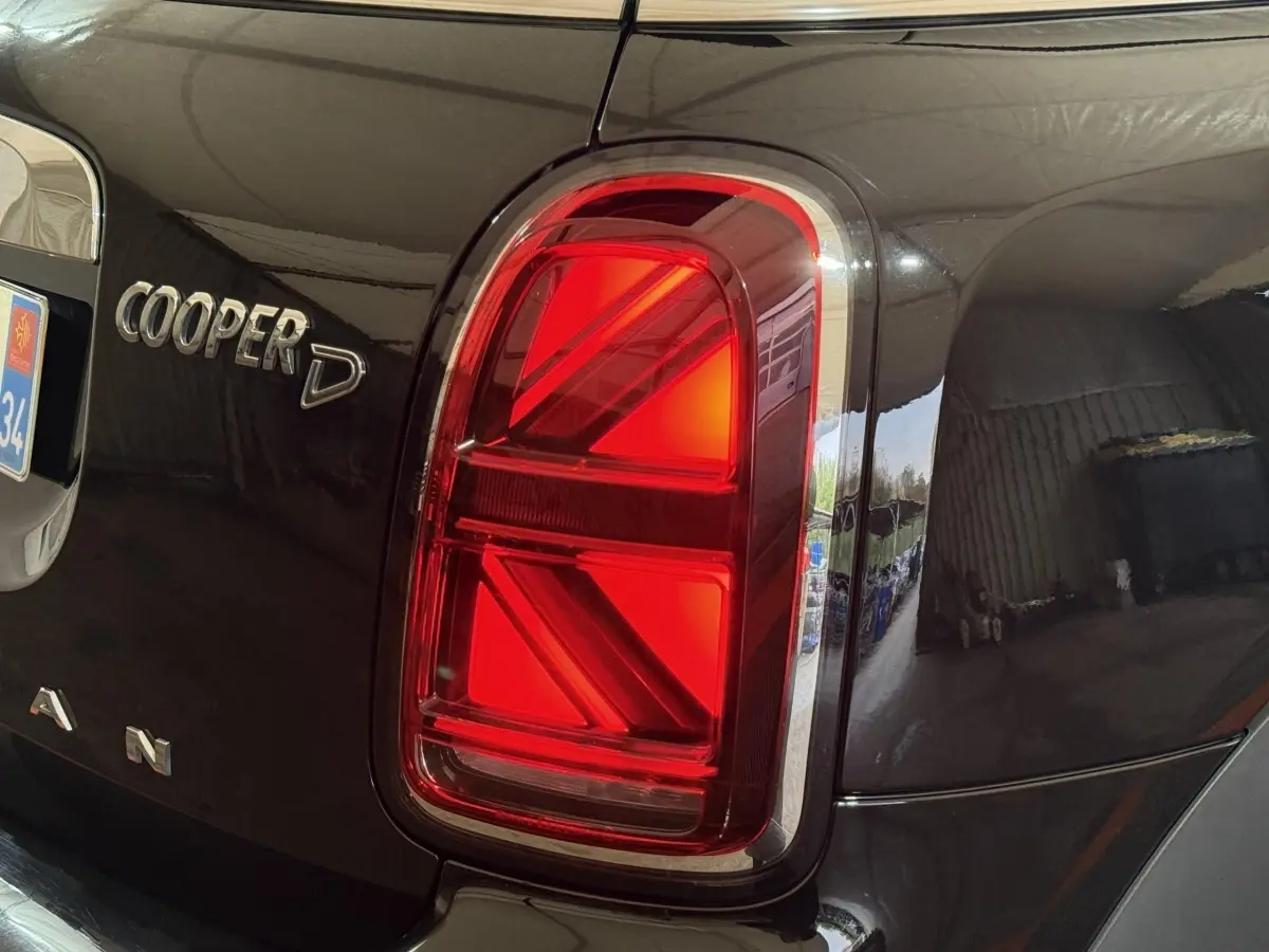 Gros plan sur le feu arrière droit rouge et l’inscription Cooper D du MINI Countryman noir 2020.