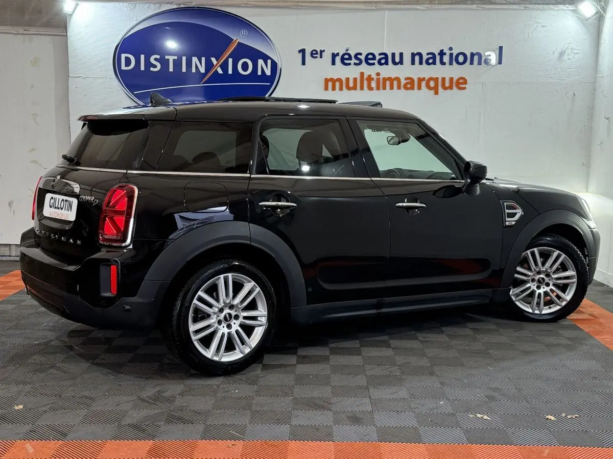 Vue de profil côté gauche d'une MINI Countryman Cooper D Business Design noire, avec jantes alliage et vitres teintées.