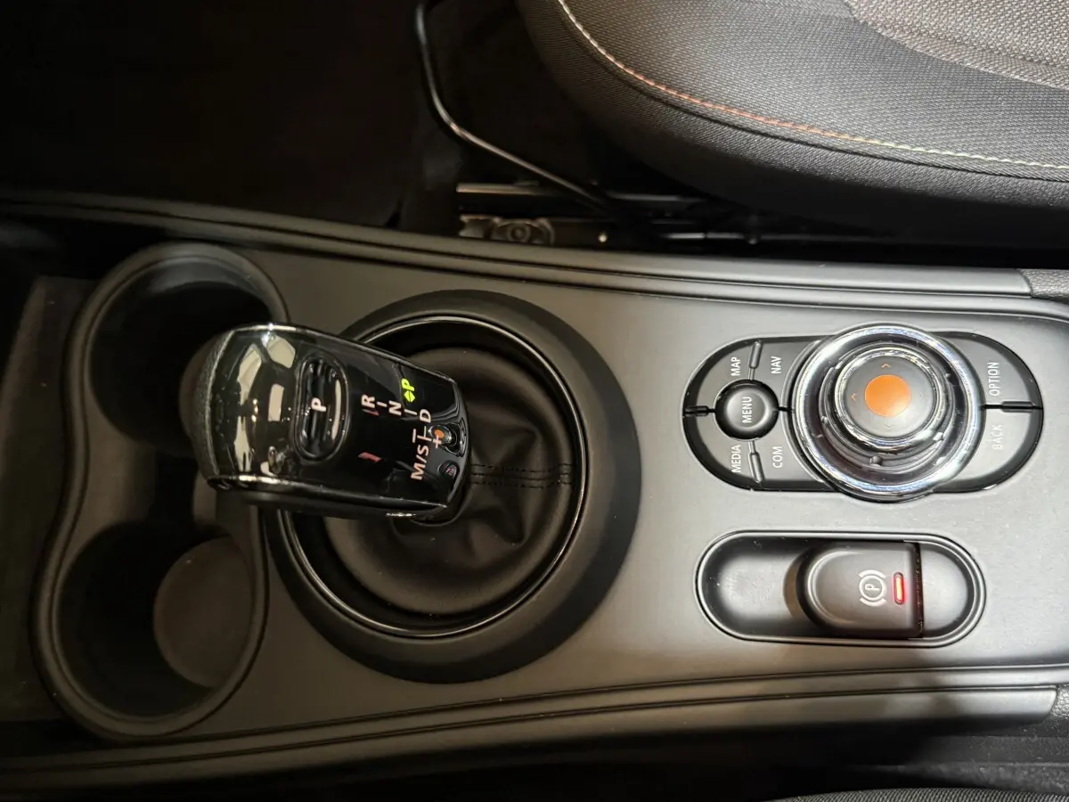 Gros plan sur la console centrale noire du MINI Countryman Cooper D 2020 avec levier de vitesses automatique et molette de contrôle.