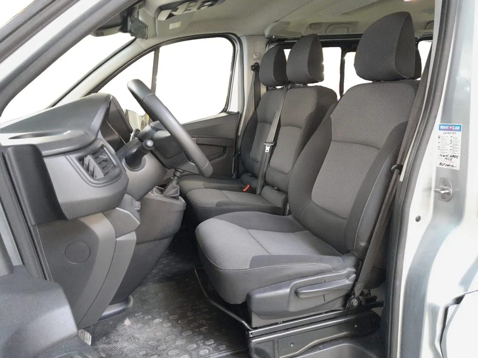 Vue intérieure côté conducteur du Renault Trafic Combi 2022, montrant les sièges gris et le tableau de bord simple.