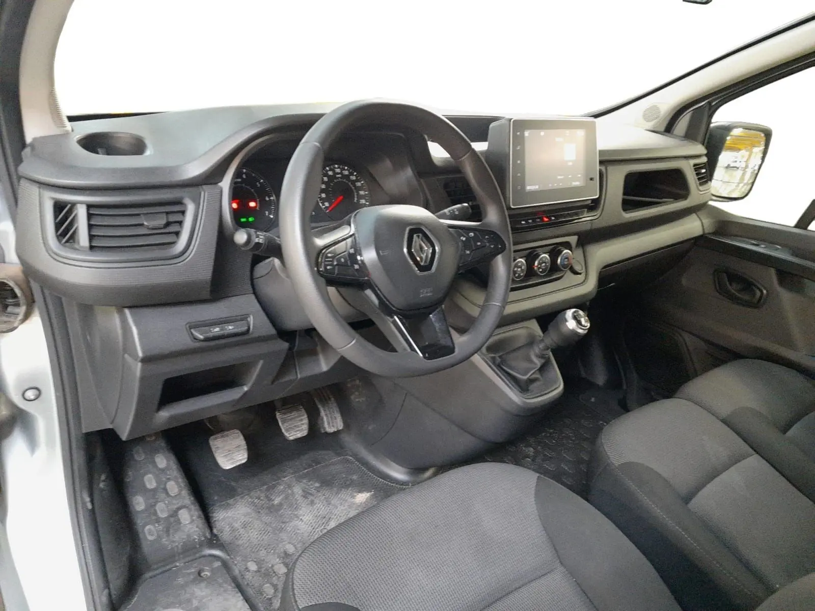 Vue intérieure côté conducteur du Renault Trafic Combi 2022 avec volant multifonction, écran tactile et boîte manuelle.