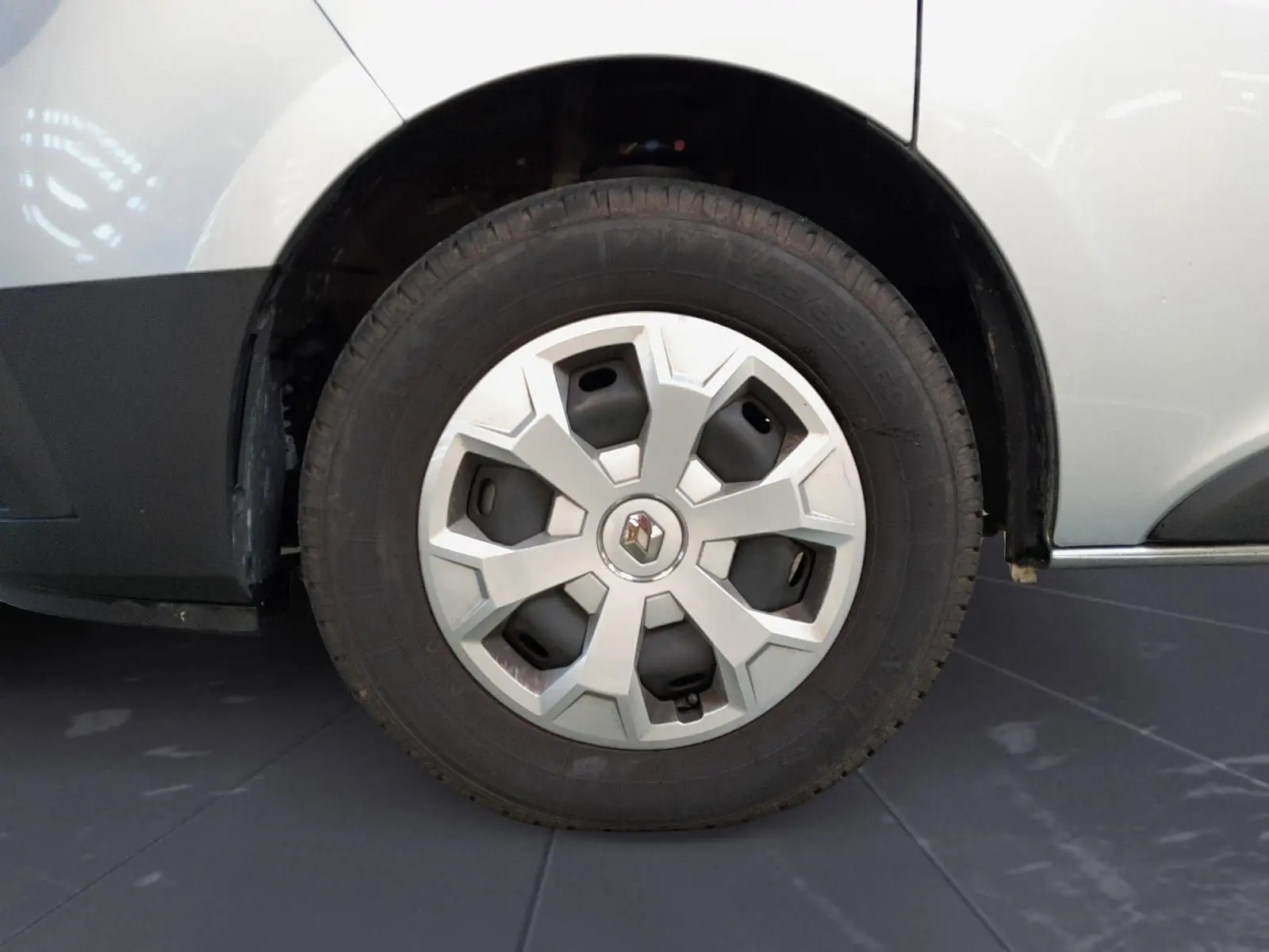 Gros plan sur la roue arrière droite d’un Renault Trafic Combi gris Highland, avec jante en alliage et logo Renault central.