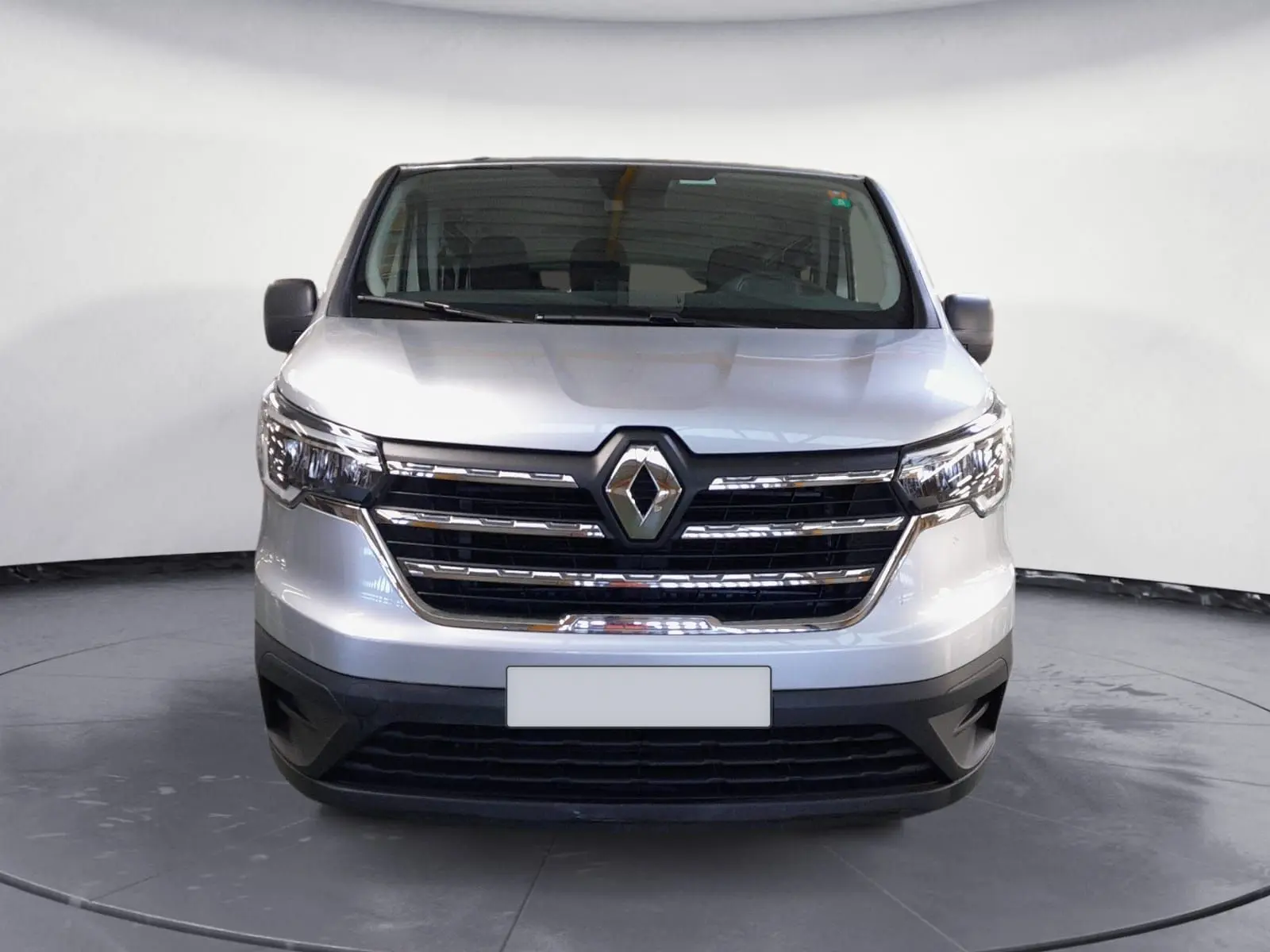 Vue frontale du Renault Trafic Combi L2 gris Highland, mettant en valeur la calandre chromée et les phares LED.
