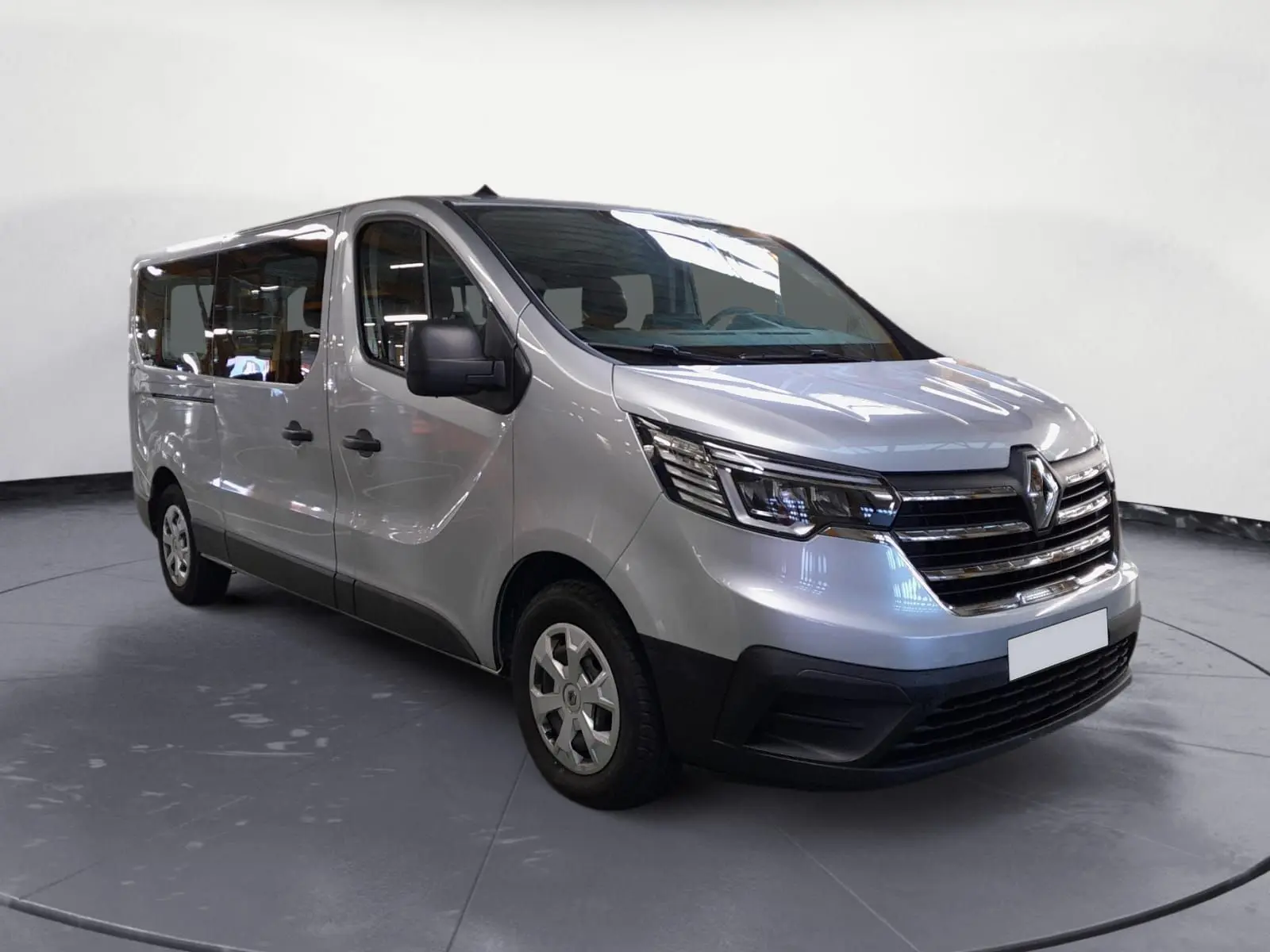 Renault Trafic Combi gris Highland en vue 3/4 avant droit, mettant en valeur ses grandes vitres latérales et sa calandre chromée.