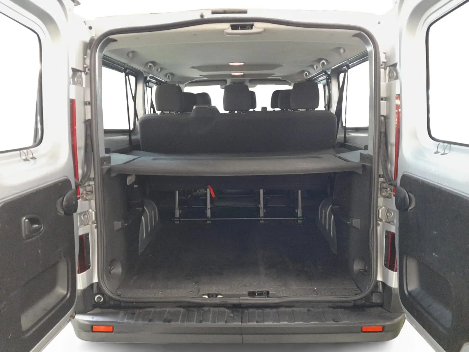 Vue arrière ouverte du Renault Trafic Combi gris Highland montrant l'espace de chargement et les sièges passagers.