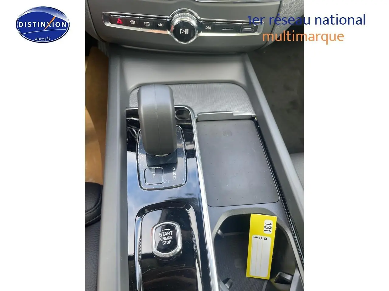 Gros plan sur la console centrale du Volvo XC60 gris 2024, avec levier de vitesse et bouton start/stop.