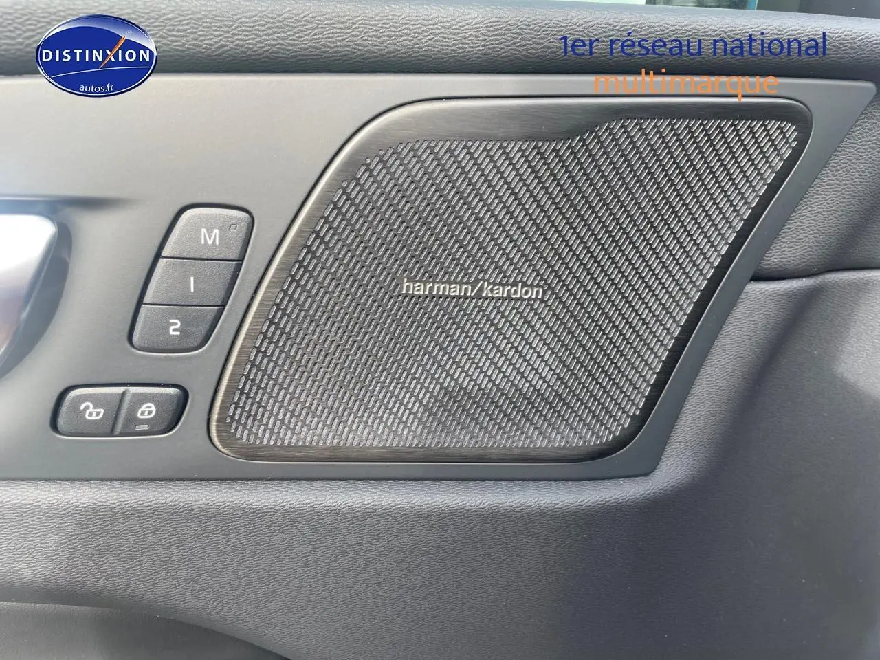Gros plan sur la porte intérieure côté gauche du Volvo XC60 gris, avec haut-parleur Harman Kardon et commandes mémoire sièges.