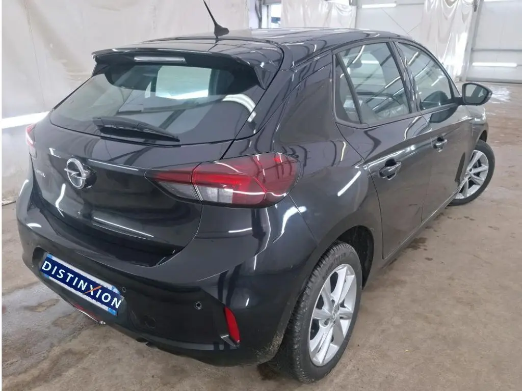 Vue 3/4 arrière droite de l’Opel Corsa F Elegance Business 2023 en noir perla avec jantes alliage et toit spoiler.