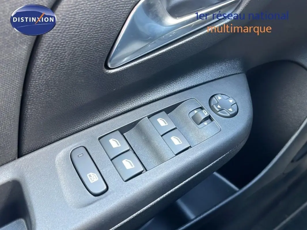 Gros plan sur les commandes électriques des vitres et rétroviseurs côté conducteur d’une Opel Corsa gris 2025.