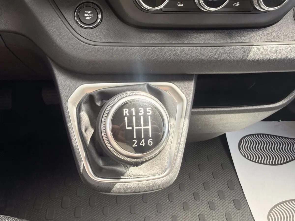 Gros plan sur le levier de vitesses manuel noir du Renault Trafic Fourgon 2025, entouré de garniture grise.