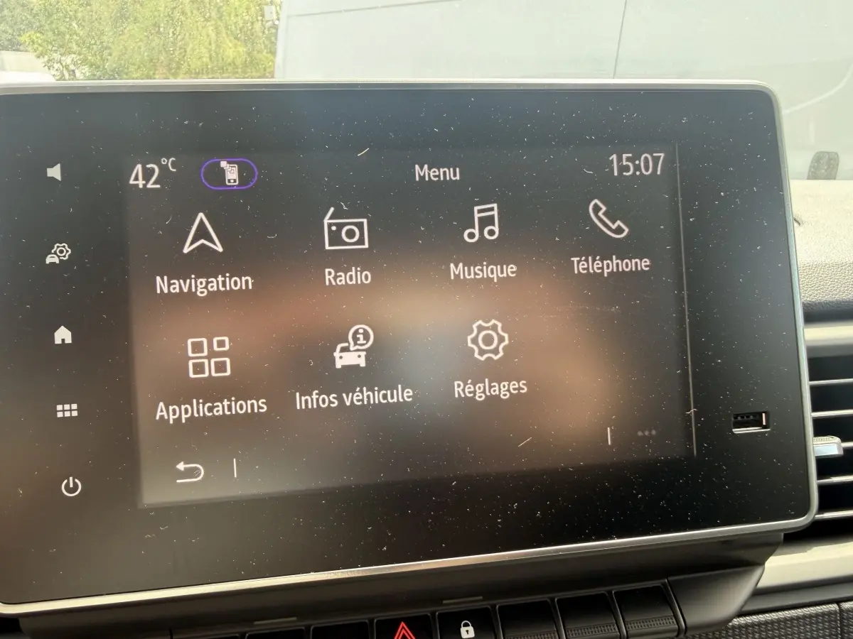 Écran tactile central du tableau de bord du Renault Trafic Fourgon blanc, affichant le menu principal multimédia.