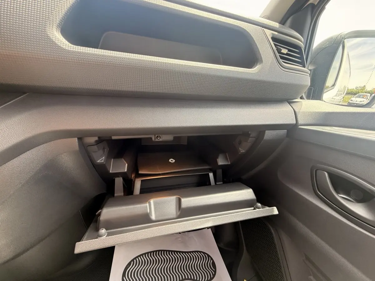 Intérieur du Renault Trafic Fourgon blanc 2025, vue sur la boîte à gants ouverte côté passager avec rangement visible.