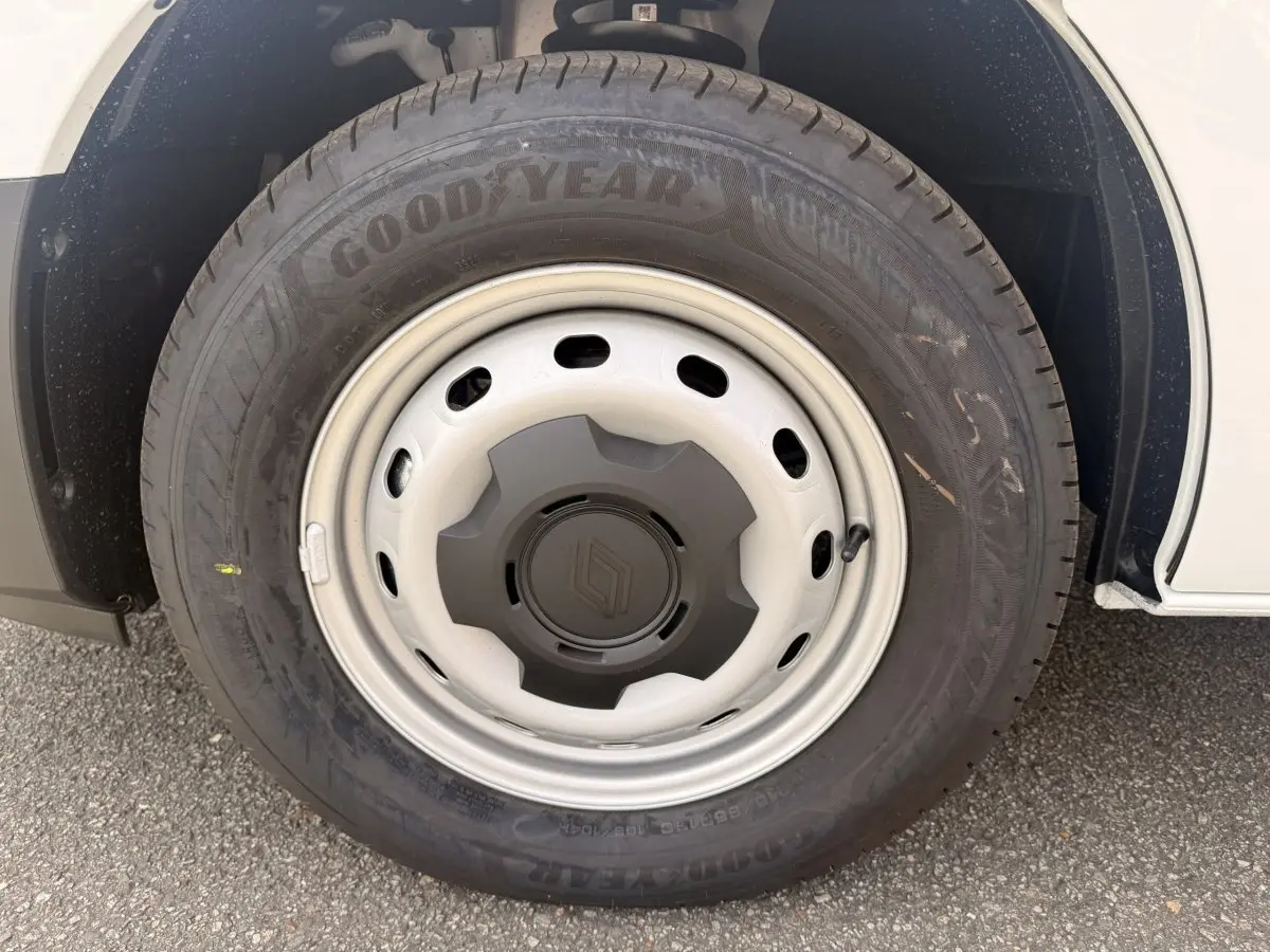 Gros plan sur la roue avant droite du Renault Trafic blanc, jante acier avec logo Renault central.