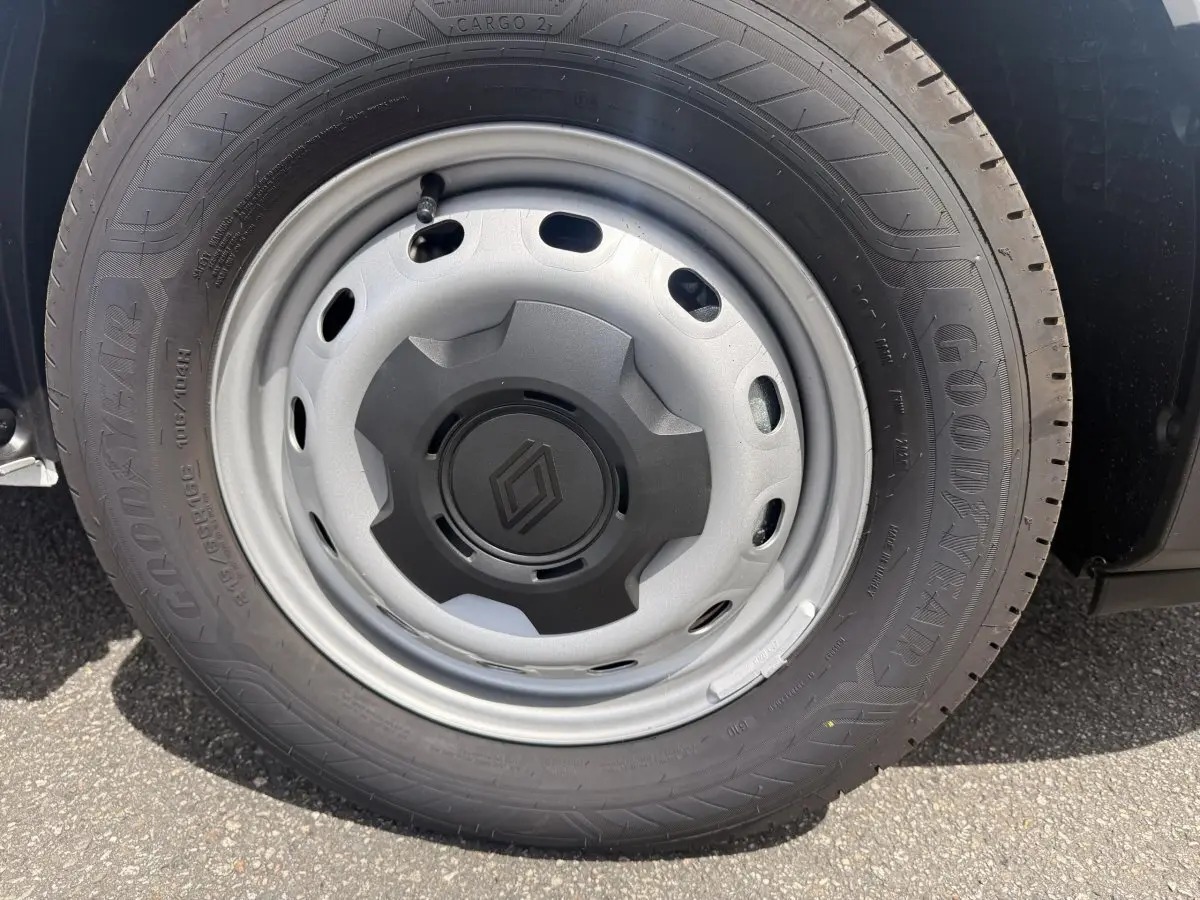 Gros plan sur la roue avant droite du Renault Trafic Fourgon blanc, jante acier avec logo Renault central noir.