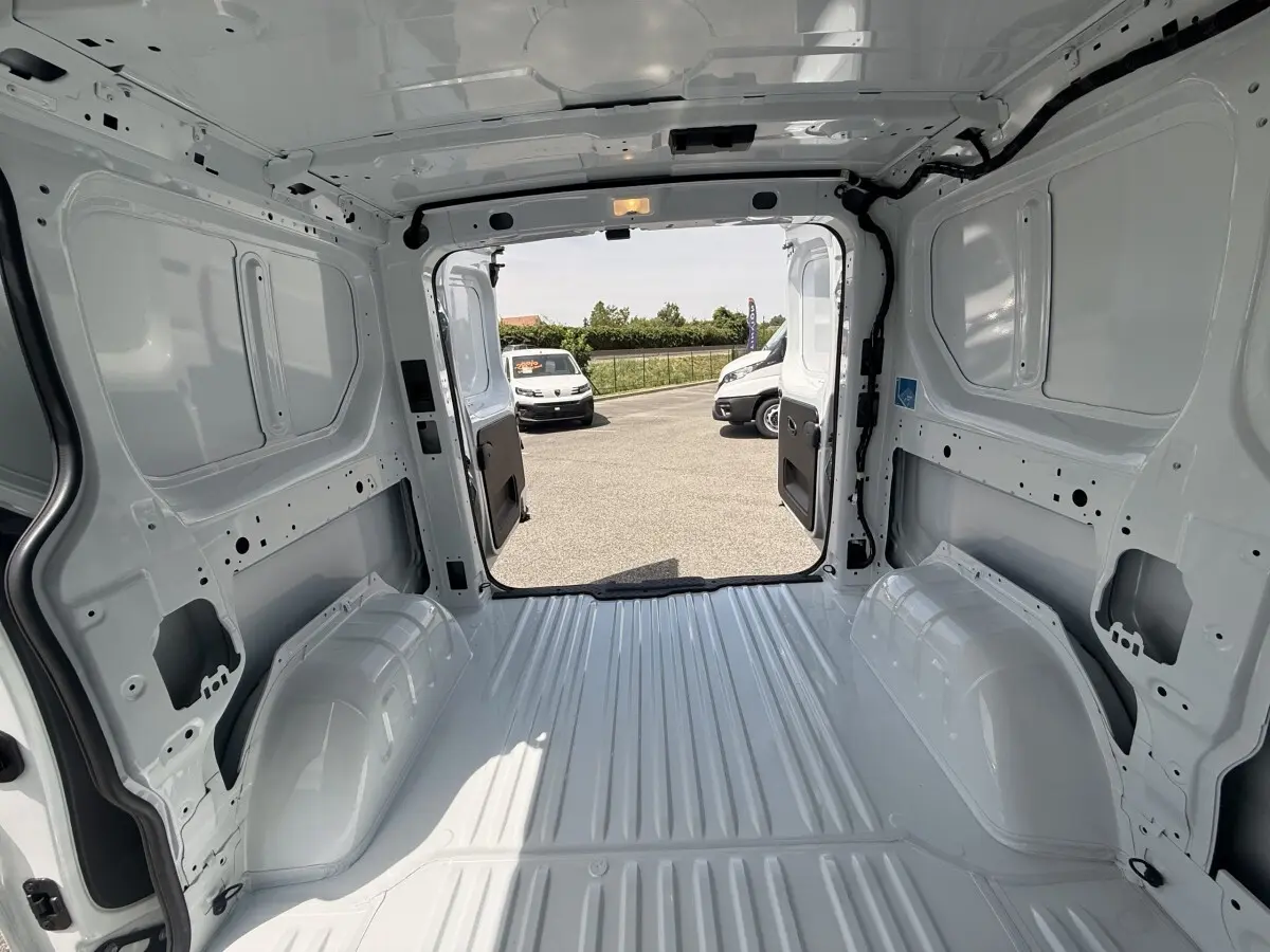 Vue intérieure arrière du Renault Trafic Fourgon blanc 2025, montrant l’espace de chargement vide et les portes ouvertes.