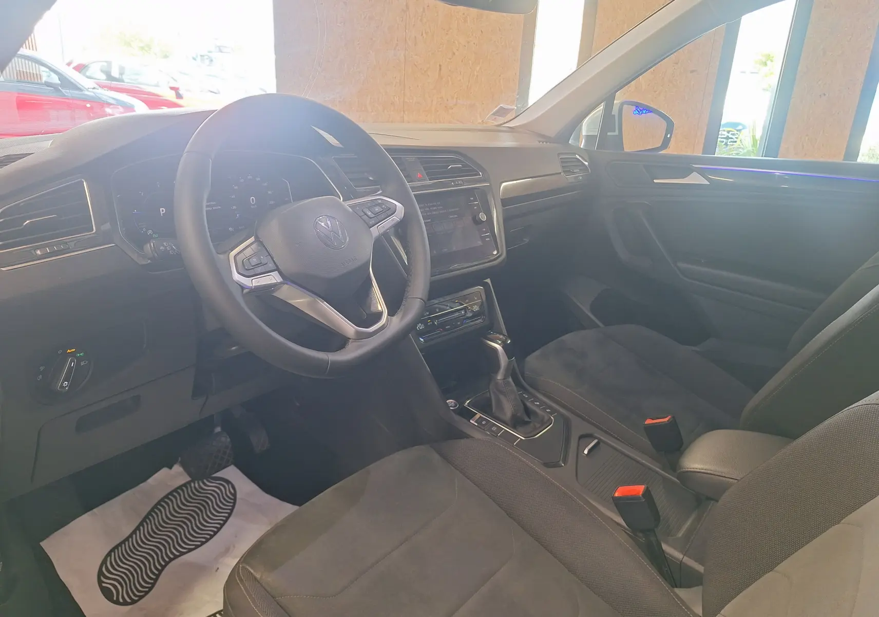 Intérieur avant droit du Volkswagen Tiguan 2021, volant cuir multifonction, sellerie microfleece noire et console centrale moderne.