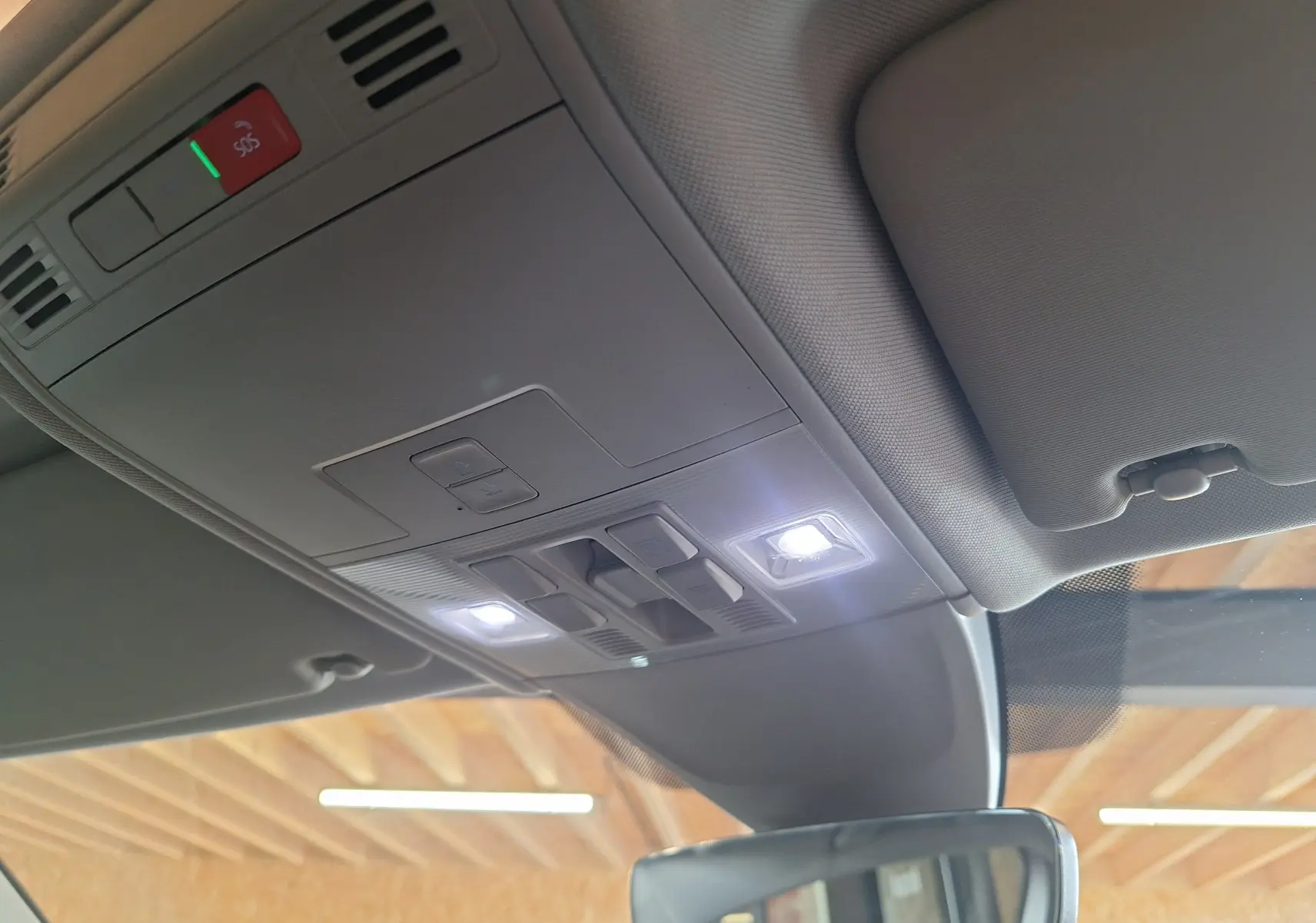 Plafonnier intérieur allumé avec commandes et toit ouvrant panoramique du Volkswagen Tiguan gris 2021 vue avant cabine