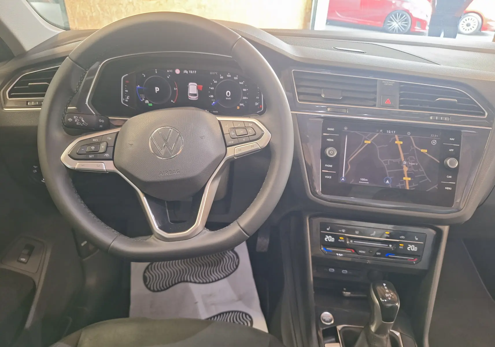 Vue intérieure du volant cuir multifonction et tableau de bord digital du Volkswagen Tiguan gris 2021 avec écran tactile central.