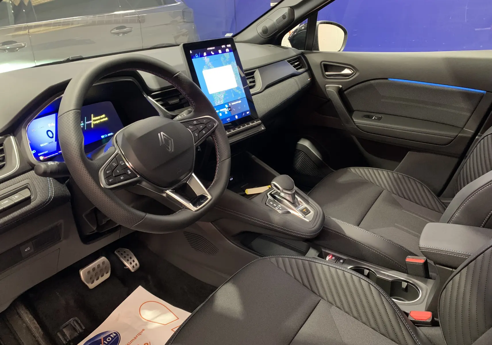 Intérieur avant droit du Renault SYMBIOZ 2025, tableau de bord numérique et écran tactile vertical, sièges noirs élégants.