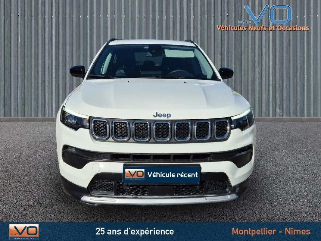 Vue frontale d'un Jeep Compass blanc 2023 avec calandre à sept fentes et phares LED distinctifs.