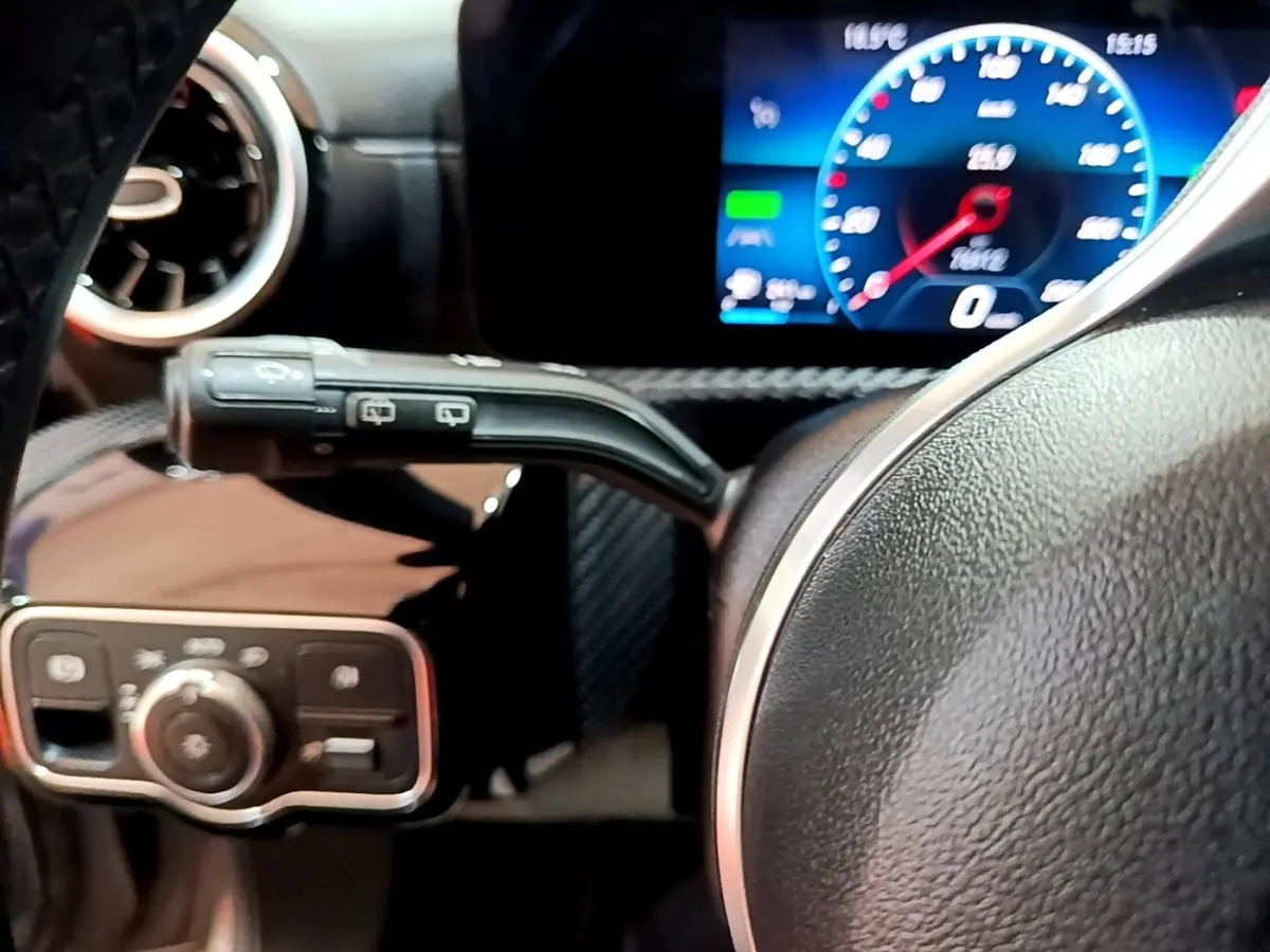 Gros plan sur le volant cuir et le tableau de bord numérique bleu d'une Mercedes Classe A A 250 e Business Line 2020.