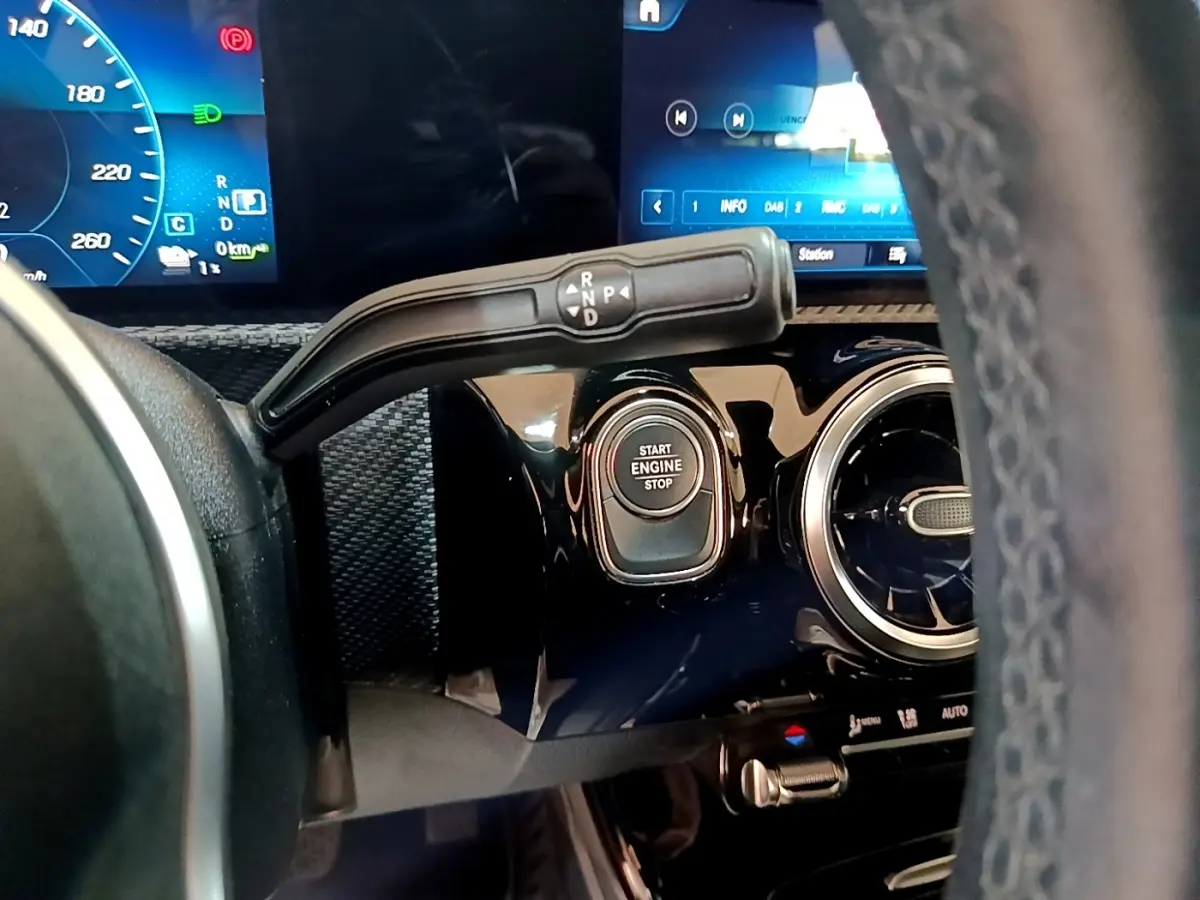 Gros plan sur le tableau de bord noir brillant côté gauche d'une Mercedes Classe A 250 e avec bouton Start Engine Stop.