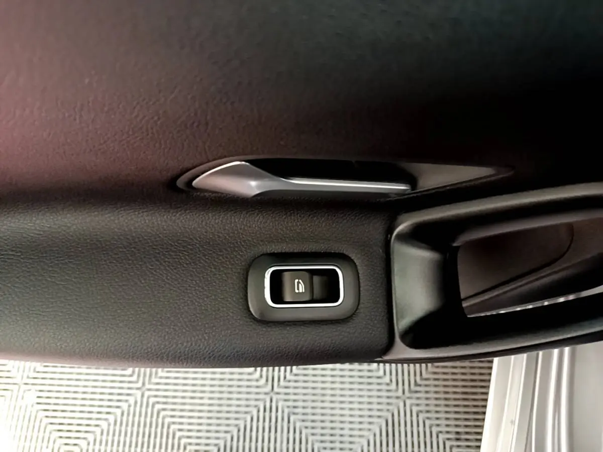 Bouton de verrouillage de porte sur la garniture intérieure côté conducteur d'une Mercedes Classe A gris foncé.