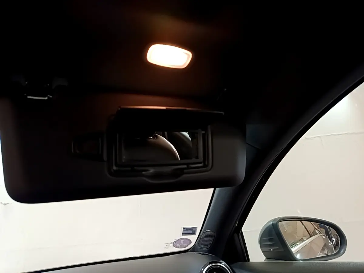 Détail intérieur du pare-soleil avec miroir éclairé et rétroviseur côté droit d'une Mercedes Classe A gris foncé de 2020.