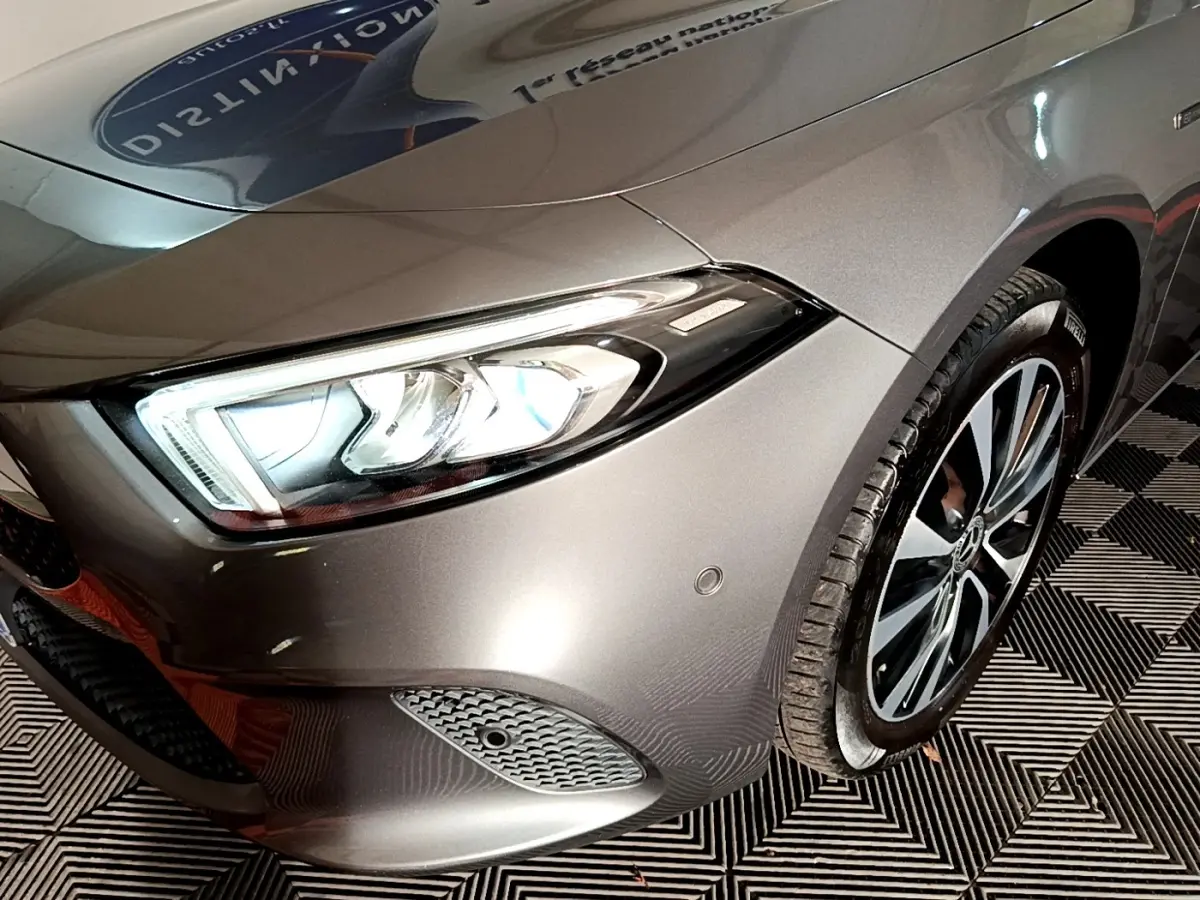 Gros plan sur l'avant droit gris foncé d'une Mercedes Classe A 250 e avec phares LED et jante alliage.