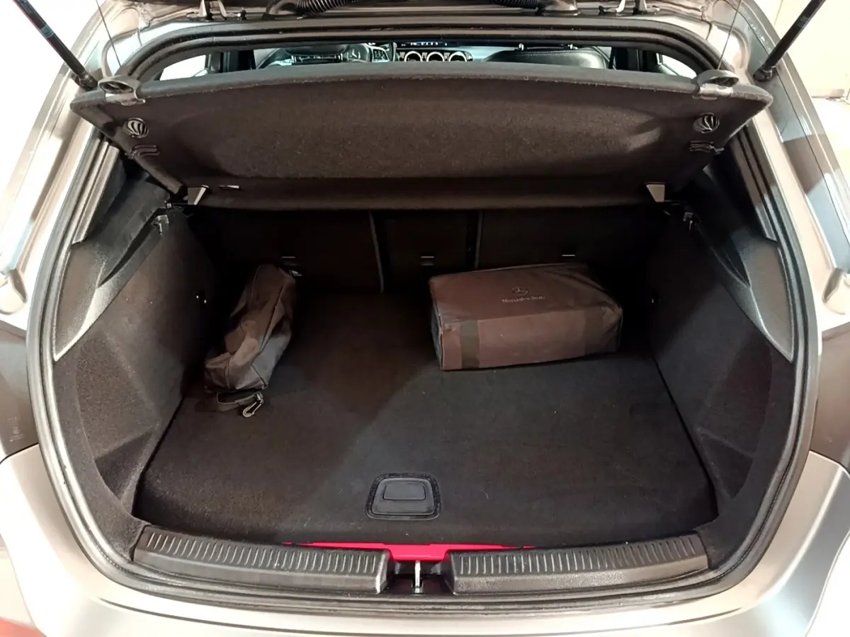 Vue du coffre ouvert d'une Mercedes Classe A 250 e Business Line gris foncé avec sacoche de rangement noire à l'intérieur.